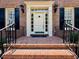 Close-up of an inviting brick front porch with black iron railings and sidelights at 105 Abbotsford Ct, Durham, NC 27712
