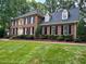 Traditional two-story brick home with lush lawn and manicured landscaping at 105 Abbotsford Ct, Durham, NC 27712