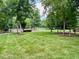 Green lawn surrounded by mature trees and shrubs, enhancing curb appeal and privacy at 105 Abbotsford Ct, Durham, NC 27712
