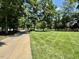 Well-manicured front lawn featuring mature trees and a paved driveway at 105 Abbotsford Ct, Durham, NC 27712