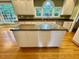 Bright kitchen features an island with granite counters, white cabinets, and stainless steel appliances at 105 Abbotsford Ct, Durham, NC 27712