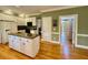 Bright kitchen features an island with granite counters, white cabinets, and stainless steel appliances at 105 Abbotsford Ct, Durham, NC 27712