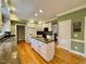 Bright kitchen features an island with granite counters, white cabinets, and stainless steel appliances at 105 Abbotsford Ct, Durham, NC 27712