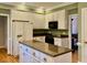 Bright kitchen features an island with granite counters, white cabinets, and stainless steel appliances at 105 Abbotsford Ct, Durham, NC 27712