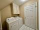 This laundry room has a washer, a dryer, cabinet, white door, and tile floor at 105 Abbotsford Ct, Durham, NC 27712