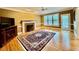 Cozy living room featuring hardwood floors, a fireplace, and large windows at 105 Abbotsford Ct, Durham, NC 27712