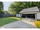 Backyard featuring a well-maintained lawn, carport, storage building, and wooden fence at 1103 S Bloodworth St, Raleigh, NC 27601