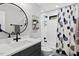 This updated bathroom offers a modern vanity, round mirror, and shower with decorative blue shower curtain at 1103 S Bloodworth St, Raleigh, NC 27601