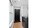This mud room features a black modern door, black washing machine and light colored wood floor at 1103 S Bloodworth St, Raleigh, NC 27601