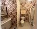Bathroom featuring floral wallpaper, white vanity, a toilet and a shower with tub at 1116 Friendly Rd, Dunn, NC 28334