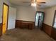 Carpeted bedroom featuring wood paneled walls and a charming built-in desk at 1116 Friendly Rd, Dunn, NC 28334