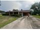 Traditional home featuring a lengthy driveway and brick exterior with attached carport at 1116 Friendly Rd, Dunn, NC 28334