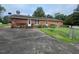 Single story brick home featuring a chain link fence and satellite dishes at 1116 Friendly Rd, Dunn, NC 28334