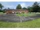 Brick ranch style home with a chain link fence and a large driveway at 1116 Friendly Rd, Dunn, NC 28334