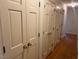 Hallway with hardwood floors and multiple white closets for ample storage at 1116 Friendly Rd, Dunn, NC 28334