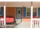 Inviting front porch with red seating and a brick facade, perfect for relaxing outdoors at 1186 Dick Holeman Rd, Timberlake, NC 27583
