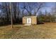 View of the shed with a white door and tan siding, complemented by a small wooden ramp at 1186 Dick Holeman Rd, Timberlake, NC 27583
