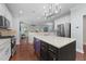 Bright kitchen features stainless appliances, an island with wine fridge, and hardwood floors at 120 Silver Bluff St, Holly Springs, NC 27540