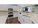 Modern kitchen featuring stainless steel appliances, white cabinets, granite countertops, and hardwood flooring at 120 Silver Bluff St, Holly Springs, NC 27540
