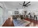 Spacious living area with hardwood floors, comfortable sofa, bar seating, and access to stairs at 120 Silver Bluff St, Holly Springs, NC 27540