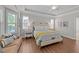 Spacious bedroom featuring hardwood floors, tray ceilings, a ceiling fan, and plenty of natural light at 120 Silver Bluff St, Holly Springs, NC 27540