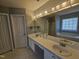 Well-lit bathroom featuring double sinks, bathtub, tiled floors, and large mirror at 121 Brentfield Loop, Morrisville, NC 27560