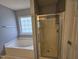 Bathroom featuring tub, shower, tiled floors, and frosted window at 121 Brentfield Loop, Morrisville, NC 27560