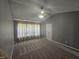 A bedroom featuring a plush carpet, vaulted ceiling, and natural light through a large window at 121 Brentfield Loop, Morrisville, NC 27560