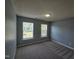Bright bedroom featuring two windows, neutral walls, and plush carpet at 121 Brentfield Loop, Morrisville, NC 27560