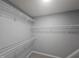Walk-in closet with installed wire shelving and neutral colored walls and carpeting at 121 Brentfield Loop, Morrisville, NC 27560
