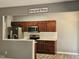 View of the kitchen with stainless steel appliances and brown cabinetry, topped with 'home sweet home' decor at 121 Brentfield Loop, Morrisville, NC 27560