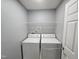 Bright laundry room with washer, dryer, and overhead shelving for organized convenience at 121 Brentfield Loop, Morrisville, NC 27560