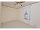 Cozy bedroom with a ceiling fan, window with lace curtains, and neutral carpeting at 124 Jack Bennett Rd, Chapel Hill, NC 27517
