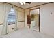 Bedroom with plush carpet, window with curtains, and swinging door access to the kitchen at 124 Jack Bennett Rd, Chapel Hill, NC 27517