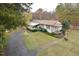 Single story home featuring a large lawn, inviting front porch and mature trees at 124 Jack Bennett Rd, Chapel Hill, NC 27517
