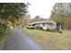 Charming single-story home with mature landscaping, covered front porch, and a circular driveway at 124 Jack Bennett Rd, Chapel Hill, NC 27517