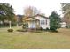 Attractive home featuring a covered porch, well-maintained lawn, and complemented by mature trees at 124 Jack Bennett Rd, Chapel Hill, NC 27517