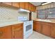 Kitchen view with white electric range and window over the laminate countertops at 124 Jack Bennett Rd, Chapel Hill, NC 27517