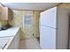 Functional laundry area with cabinets, large refrigerator, and carpeted floors for convenience at 124 Jack Bennett Rd, Chapel Hill, NC 27517