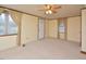 Cozy living room features carpet, ceiling fan, and two windows with curtains at 124 Jack Bennett Rd, Chapel Hill, NC 27517