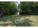 Landscaped backyard features mature trees and an outbuilding at 1344 Highland Dr, Wake Forest, NC 27587
