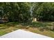 Landscaped backyard features a white deck, mature trees, and an outbuilding at 1344 Highland Dr, Wake Forest, NC 27587