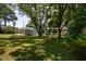 Expansive backyard showcasing mature trees, lawn, and various storage buildings at 1344 Highland Dr, Wake Forest, NC 27587