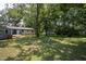 Spacious backyard featuring mature trees, lush green lawn, and unique windmill decoration at 1344 Highland Dr, Wake Forest, NC 27587