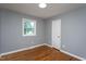 This bedroom features a window, hardwood floors, fresh paint, and a white door at 1344 Highland Dr, Wake Forest, NC 27587