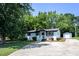 Charming home featuring a manicured lawn, lush landscaping, and a driveway leading to a detached storage shed at 1344 Highland Dr, Wake Forest, NC 27587