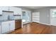 Kitchen with white cabinets, stainless steel appliances, hardwood floors, and a view to the backyard through glass doors at 1344 Highland Dr, Wake Forest, NC 27587