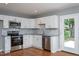 Updated kitchen featuring stainless steel appliances, white cabinetry, and beautiful hardwood flooring at 1344 Highland Dr, Wake Forest, NC 27587