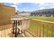 Cozy balcony with outdoor seating and a view of the neighborhood homes and manicured lawn at 1516 Tamarisk Ln, Durham, NC 27703