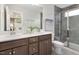 Modern bathroom featuring a double vanity, quartz countertop, and walk-in shower with gray tiling at 1516 Tamarisk Ln, Durham, NC 27703